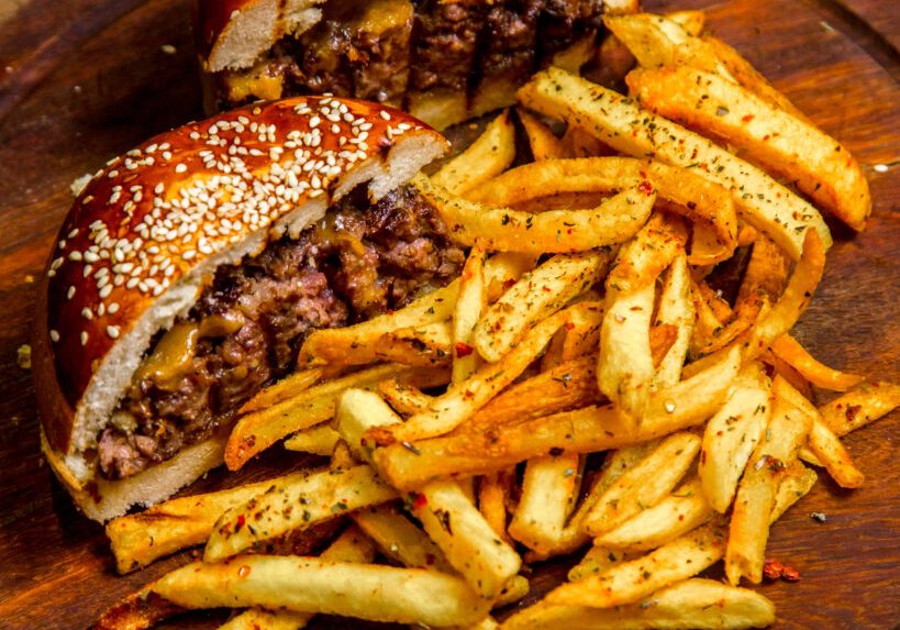 meat burger on wooden board french fries side view