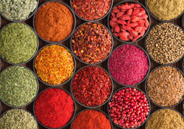 bright Indian spices and herbs in cups, top view. background for packing with condiments.